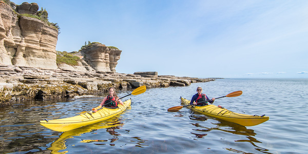 Two kayakers in front of Grosse Île au Marteau at Mingan Archipelago National Park Reserve.