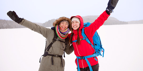 Deux jeunes femmes s’amusent en hiver au parc national de la Mauricie.