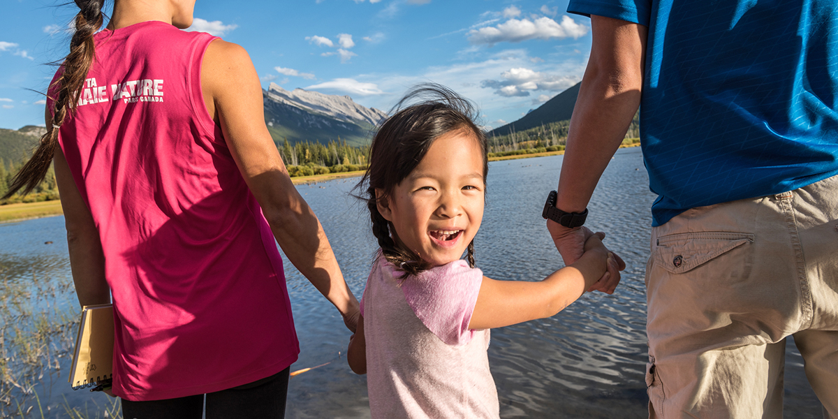 A family enjoys the views of Mount Rundle and Sulphur Mountain in Banff National Park.