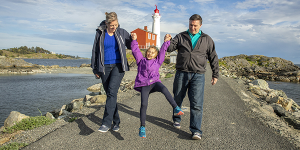 Two parents play with their little girl on the Causeway at Fisgard Lighthouse National Historic Site.