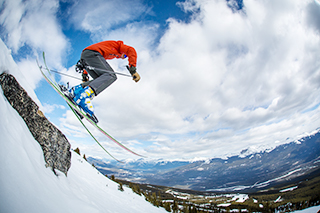 Un jeune homme fait du ski alpin à la station de ski Marmot Basin au parc national Jasper.
