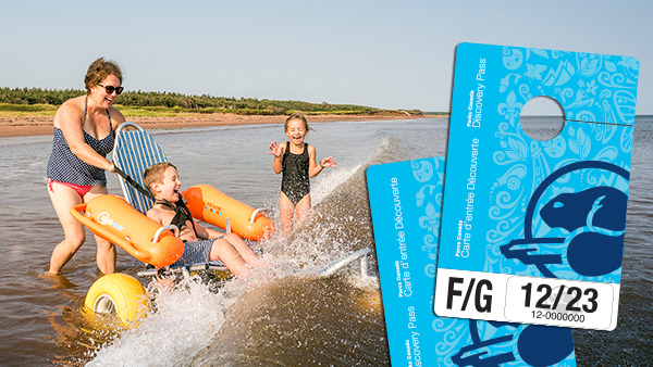 Une image de la carte d’entrée Découverte superposée à une photo d’une famille qui utilise un fauteuil roulant de plage pour s’amuser dans l’eau au parc national de l’Île-du-Prince-Édouard.